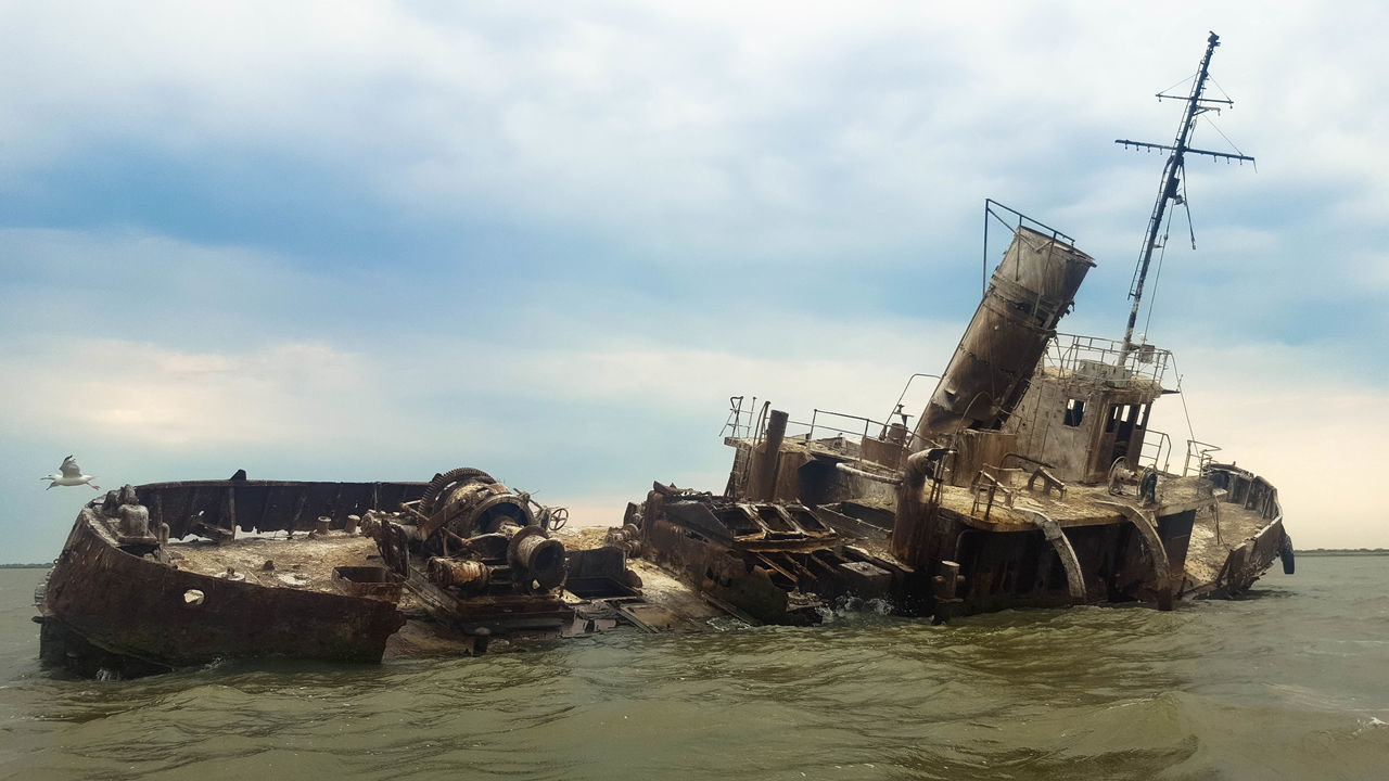 ABANDONED SHIP AT SEA AGAINST SKY