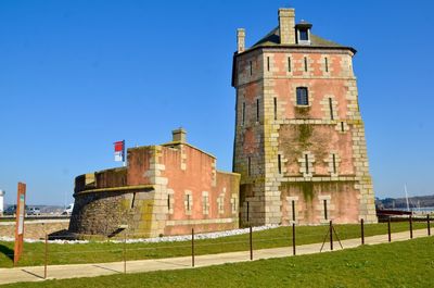 Low angle view of historic building against clear blue sky