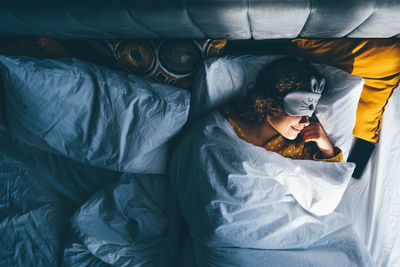 High angle view of woman lying on bed at home