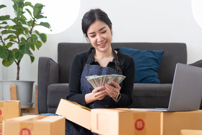 Portrait of young woman sitting on sofa at home