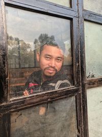 Portrait of a man looking through window