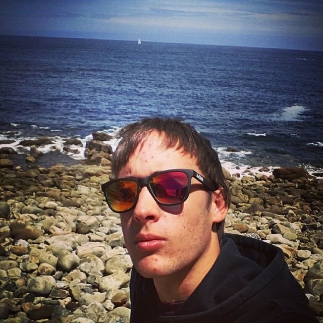 sea, headshot, water, lifestyles, beach, young adult, sunglasses, portrait, person, looking at camera, leisure activity, head and shoulders, sky, young men, shore, front view, vacations, sunlight