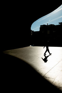 Silhouette man walking in city