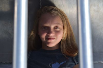 Portrait of smiling girl looking through window