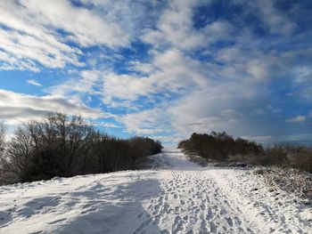 Snow covered field against sky