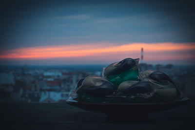 Close-up of food on beach against sky during sunset