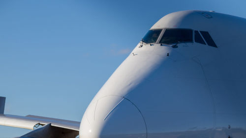 Low angle view of airplane against clear blue sky