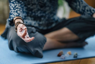 Low section of woman meditating at home