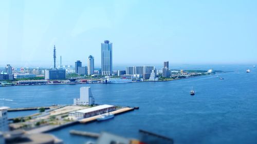 City at waterfront against blue sky