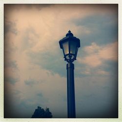 Low angle view of street light against cloudy sky