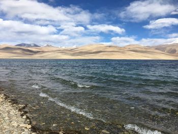 Scenic view of sea and mountains against sky