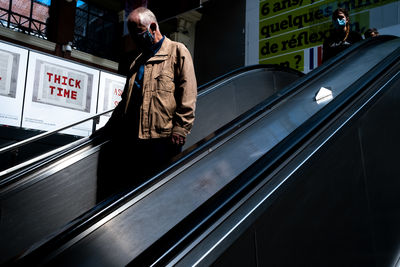 Man standing on escalator