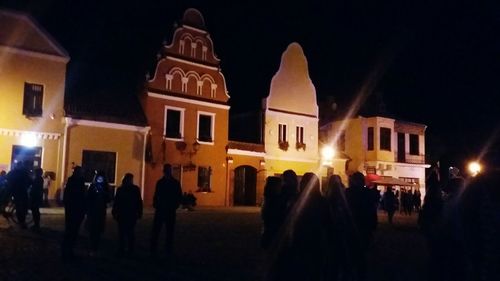 People at illuminated temple against sky at night