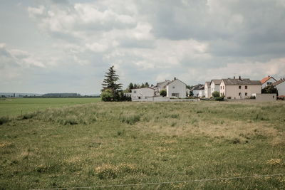 Houses on field against sky