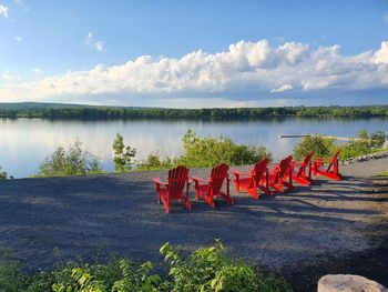 Red deck chairs by the river.