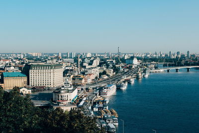 High angle view of townscape by sea against clear sky