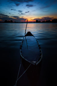 Close-up of rowboat moored in sea against sky