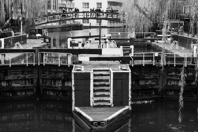 Stack of boats moored in canal by buildings in city