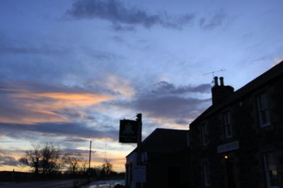 Low angle view of houses against sky during sunset