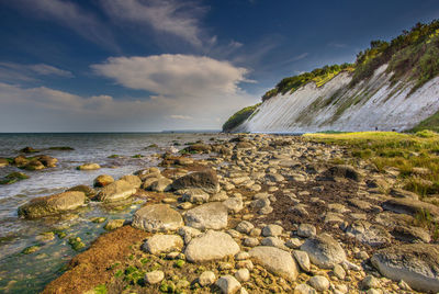 Rocks by sea against sky