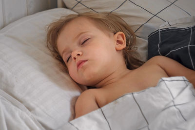 Peaceful adorable baby sleeping on a bed at home. slumbering little child. two year old girl sleeps