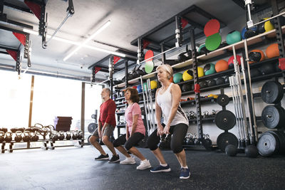 Group of fit seniors in gym working out with kettlebells