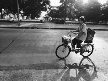 Full length of man riding bicycle on road