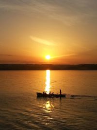 Silhouette boats in sea against sky during sunset