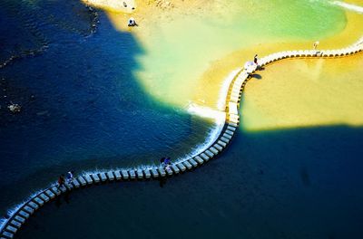 High angle view of people walking on footbridge amidst river