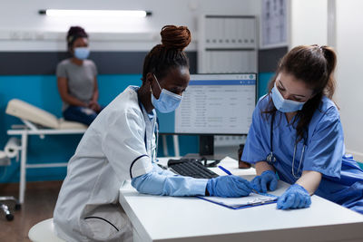 Side view of doctor examining patient in office