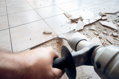 Home renovation project with man removing floor tiles