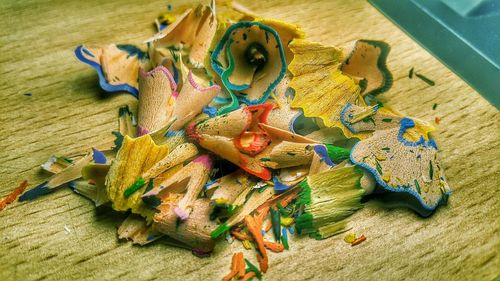 Close-up of colorful pencil shavings on wooden table