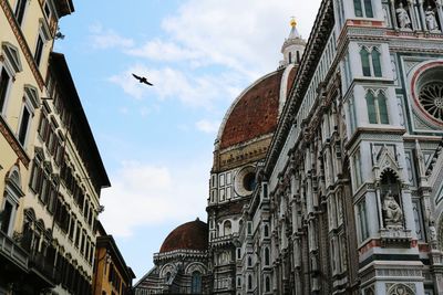 Low angle view of buildings against cloudy sky