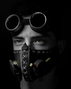 Close-up portrait of young man against black background