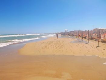 Scenic view of beach against blue sky