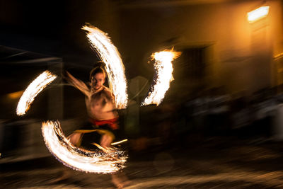 Blurred motion of man with fire crackers at night