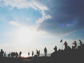 People at beach against sky