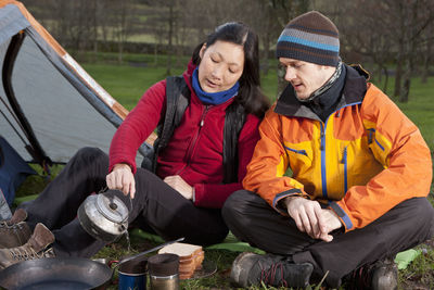 Couple preparing hot beverage at campsite in the uk