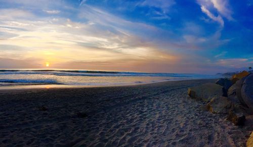 Scenic view of beach against sky during sunset