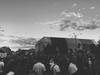 People on street in city against sky