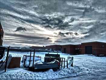 Snow covered landscape against cloudy sky