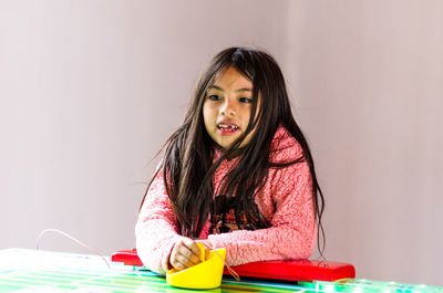 Portrait of cute girl in drinking glass on table