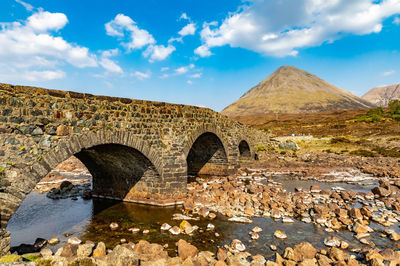 Arch bridge over water against sky