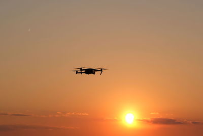 Low angle view of silhouette airplane against sky during sunset