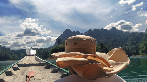 View of a man sitting on mountain against sky