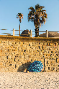 Umbrella leaning on wall at beach