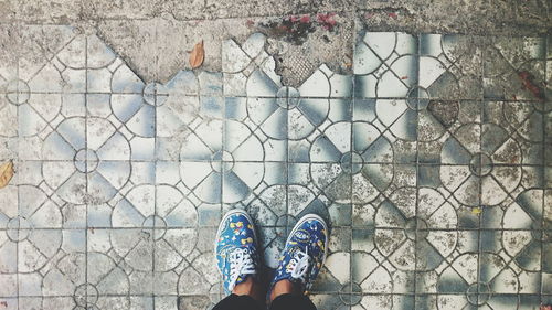 Low section of man standing on tiled floor