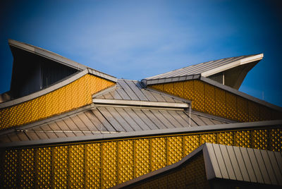 Low angle view of modern building against blue sky