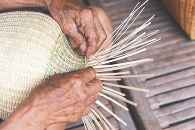 High angle view of person making wicker decoration