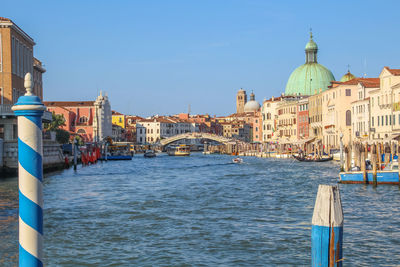 Canal amidst buildings against clear sky